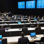 통역사 직무 소개 - A professional conference scene featuring a diverse group of interpreters working simultaneously at ...